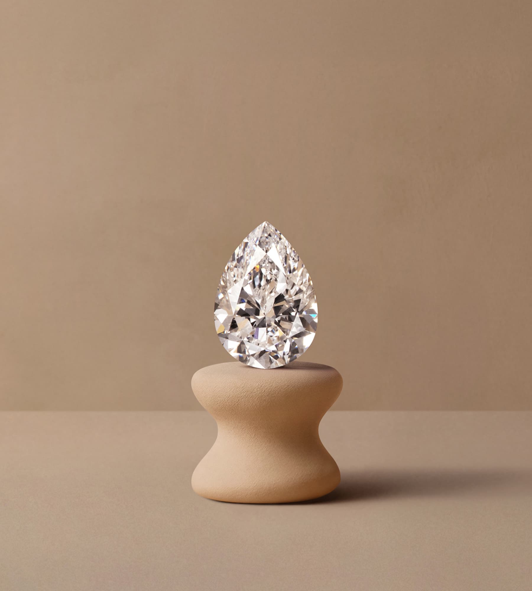 Diamant taille poire posé sur podium céramique beige