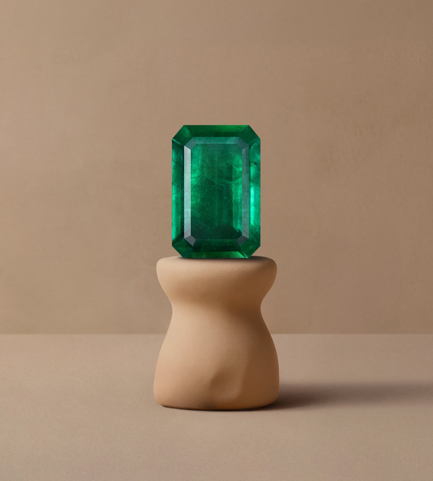 Émeraude verte taille émeraude posée sur podium céramique beige